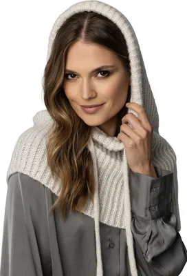 A woman wearing a beige hooded scarf over a gray shirt.