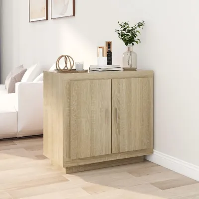 A wooden sideboard with two doors is placed in a room next to a white sofa and a wall.