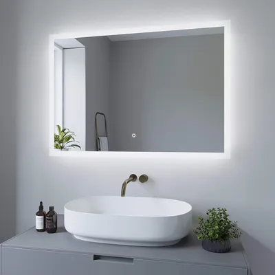 A modern bathroom vanity with a sink and a large LED mirror.
