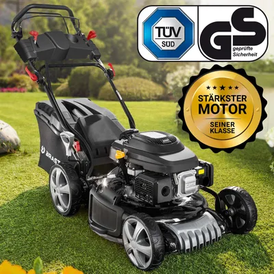 A black and silver BRAST petrol lawnmower is shown on a green lawn with a blurred background of trees and bushes. There are several certification logos and a gold starburst badge with text on the image.