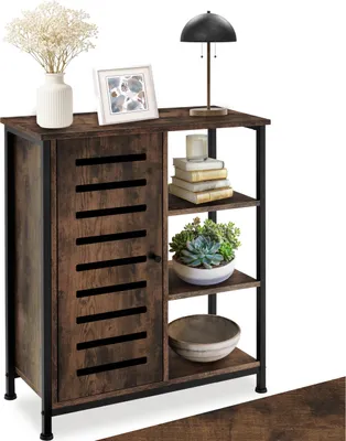 A wooden sideboard with black metal accents, decorated with a vase of flowers, a framed picture, a lamp, books, a plant, and a bowl.