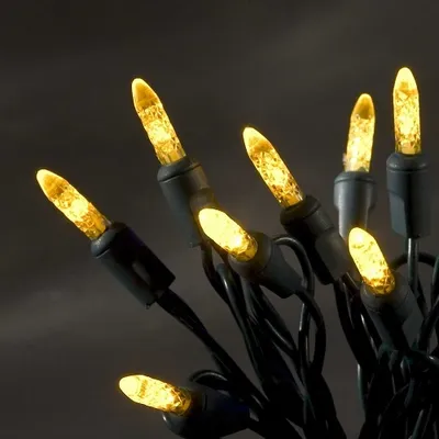A close-up of yellow LED string lights against a dark background.