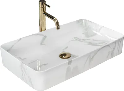 A rectangular white basin with a marble-like pattern and a gold faucet.