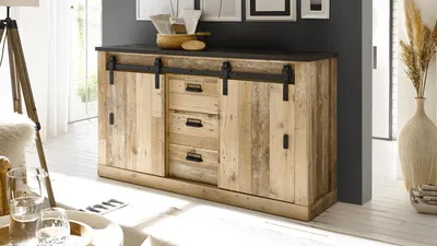 A sideboard with sliding barn doors and drawers in a room setting.