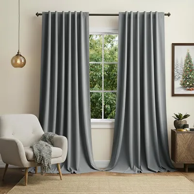 A living room scene with a chair, curtains, and a window.