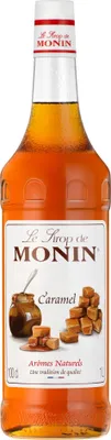 A bottle of Monin Caramel syrup against a white background.