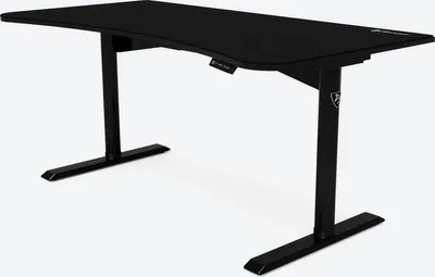 A black gaming desk with a curved front edge and adjustable height legs, shown against a white background.