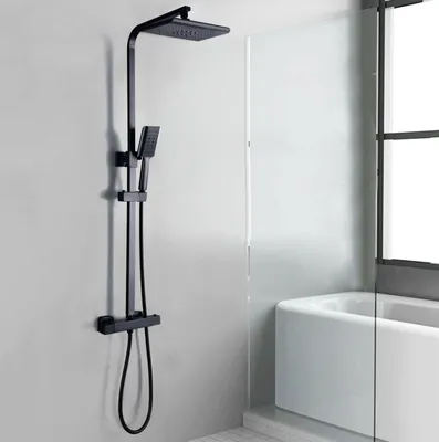 A black shower system mounted on a light gray wall next to a white bathtub.