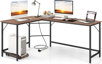An L-shaped desk with two computer monitors, a laptop, a desk lamp, headphones, books, and a computer tower on a rolling stand.