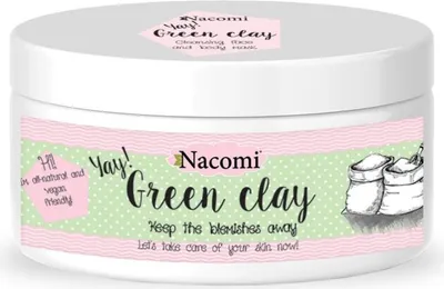 A white jar of Nacomi Green Clay face and body mask is shown against a white background. The label has a pink wavy border and a green polka dot pattern. Text and illustrations are present on the label.
