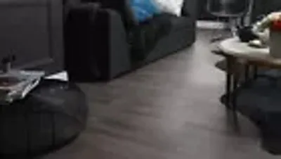A living room scene with a couch, coffee table, and flooring.