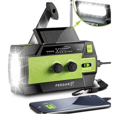 A survival radio with a flashlight and solar panel is shown, with a smartphone connected and charging.