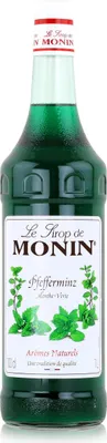 A bottle of Monin Peppermint syrup on a white background.