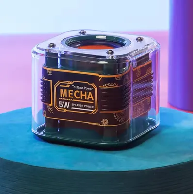 A close-up shot of a small, square Bluetooth speaker with a transparent casing.