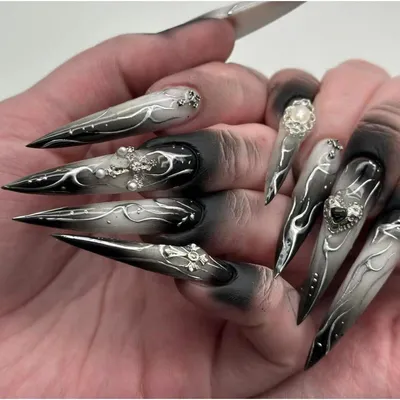 Image de Ongles artificiels en forme de stiletto, extrêmement longs, de couleur noire, pour Halloween, avec des décorations 3D en forme de cœur, de croix, des motifs argentés, des flammes et des perles, style gothique. Lot de faux ongles avec colle pour application