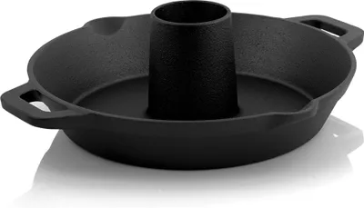 A black cast iron chicken roaster with a central cone and a drip tray is shown against a white background.