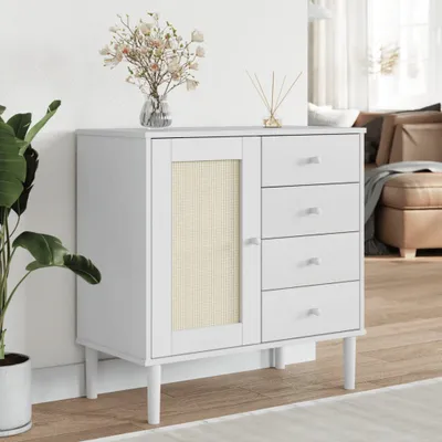 A white sideboard with rattan-optic details and four drawers, placed in a room setting with a plant and decorative items.