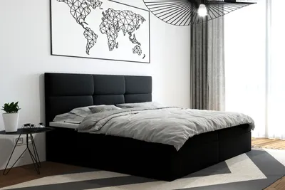 A bedroom scene with a black boxspring bed.