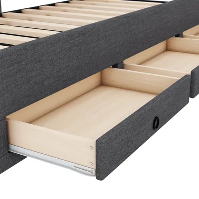 A close-up view of a bed frame with drawers open, showing the wooden slats and the fabric upholstery.