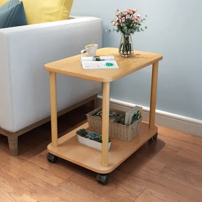 A small wooden side table with two shelves, placed next to a white sofa in a living room.