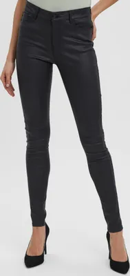 A person wearing black skinny jeans and black high heels.