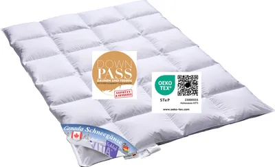 A white down comforter is laid out flat on a white background, with several certification labels placed on top of it.