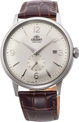 A close-up studio shot of an Orient Bambino watch with a brown leather strap.