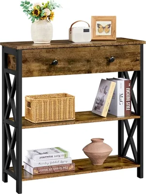 A narrow console table with a rustic, industrial design, featuring a wooden top with a drawer, and two open shelves below. It is decorated with a vase of flowers, a small radio, a framed picture, a woven basket, books, and a decorative vase.