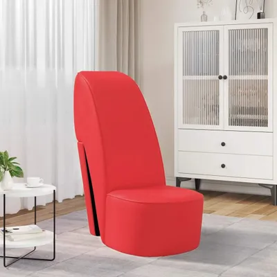 A red high-heeled shoe-shaped chair is placed in a room with a white cabinet and a small round table.