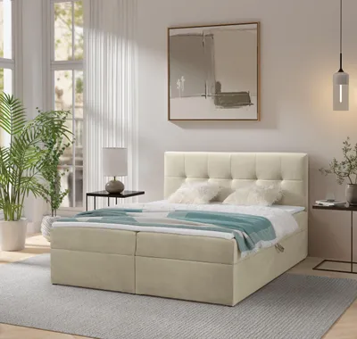 A bedroom scene with a bed, nightstand, plant, and artwork.