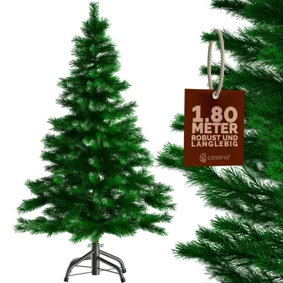 A green artificial Christmas tree with a tag attached to one of its branches.