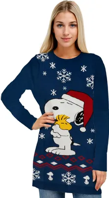 A woman is modeling a blue Christmas sweater with Snoopy and Woodstock on it.