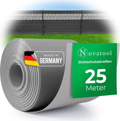 A roll of grey privacy screen material with German flag and product information labels, in front of a blurred fence and grass.
