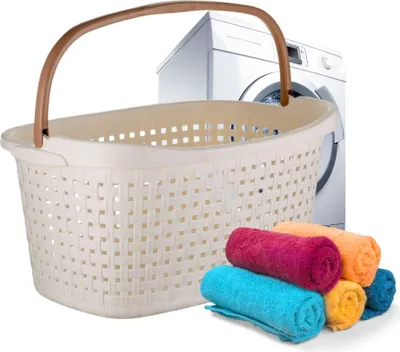 A laundry basket with a washing machine in the background and rolled towels in the foreground.