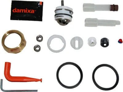 A collection of plumbing parts and a tool laid out on a white background.