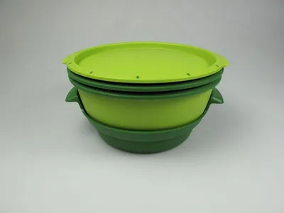 A stack of two green bowls with lids on a light gray background.