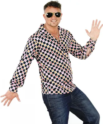 A man wearing a colorful 70s-style shirt and jeans, posing against a white background.