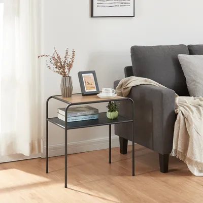 A small side table with decorative items and books next to a sofa.