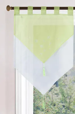 A close-up view of a green and white valance curtain hanging on a window rod.