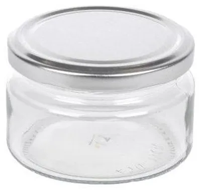 A clear, studio shot of an empty glass jar with a silver lid.