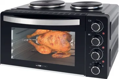 A black mini oven with a rotisserie chicken inside, set against a white background.
