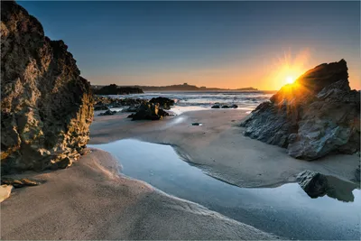 Produktbild von Wallario selbstklebendes Poster - Sonnenuntergang hinter einem Felsen am Strand, Größe: 61 x 91,50 cm