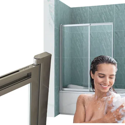 A woman is taking a shower behind a shower enclosure with green tiled walls.