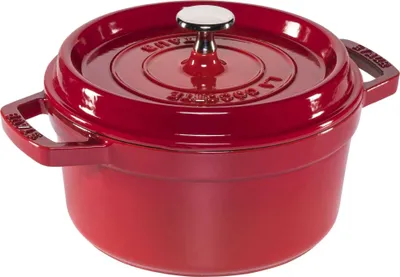 A red Staub cast iron pot with a lid.