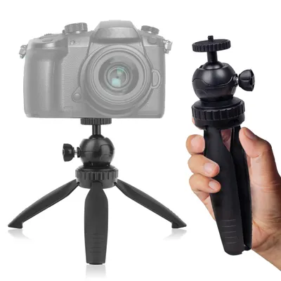 A black mini tripod with a ball head is shown, with a greyed-out DSLR camera mounted on one tripod and a hand holding another tripod on the right side of the image.