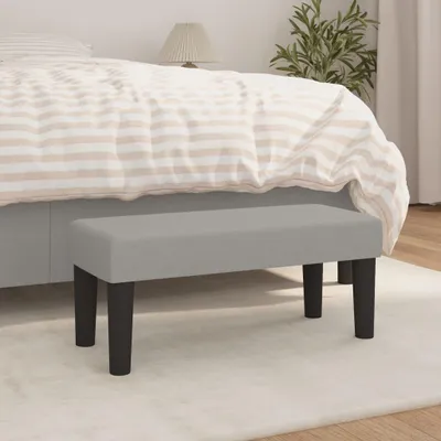 A bench in front of a bed in a bedroom.