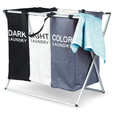 A three-compartment laundry hamper with a metal frame, shown against a white background. A blue towel is draped over one of the compartments.