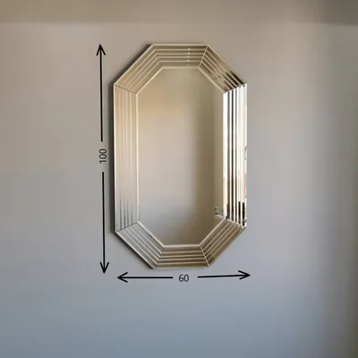 A mirror hanging on a wall with dimensions indicated.