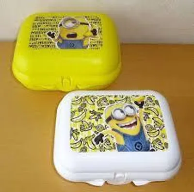 Two Minion-themed plastic containers are displayed on a wooden surface.
