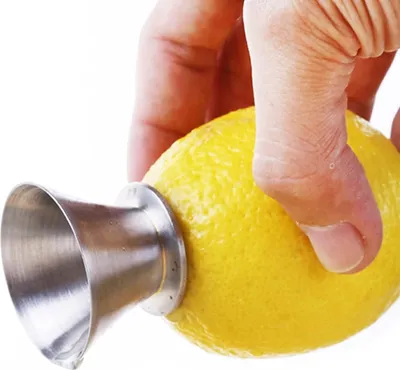 A hand is holding a lemon with a metal juicer attachment inserted into it.